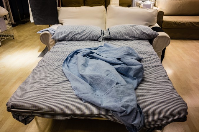 带床拉出沙发 带皱纹床单和枕头